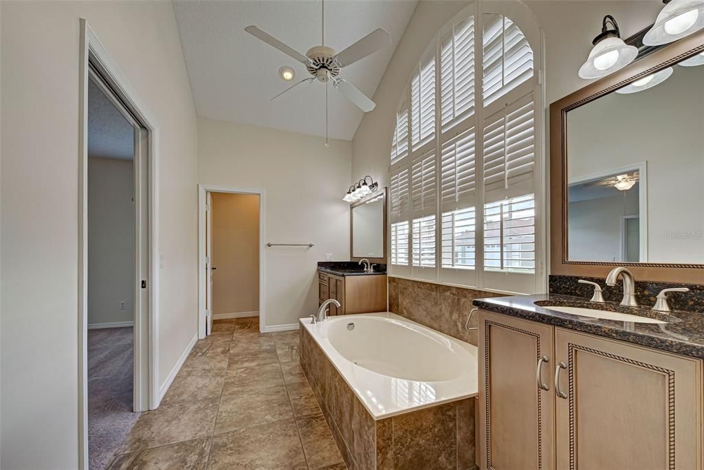 Updated primary bathroom is sure to please with its separate vanities with granite countertops, garden tub, private water closet and many windows for natural light.