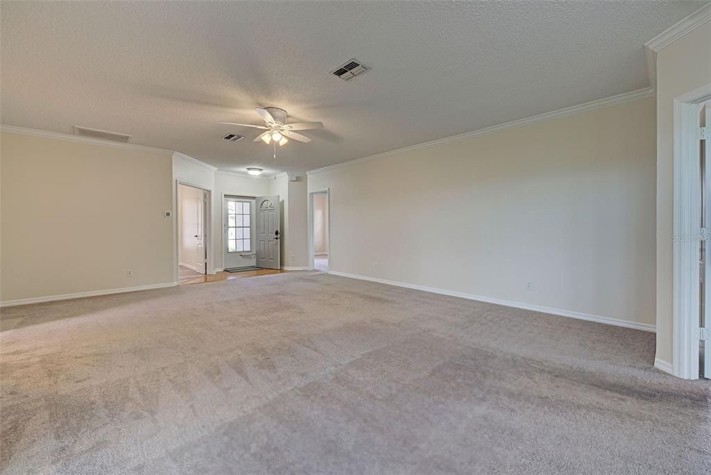 Another picture of the great room with crown molding and new fans and blinds.