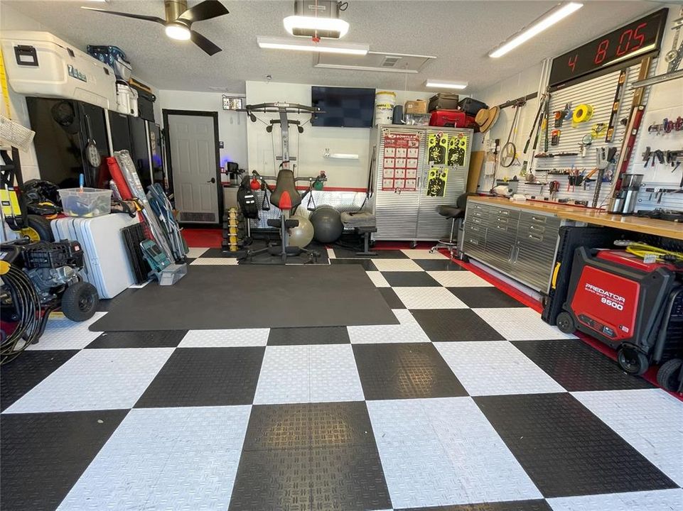 Garage with workspace, ceiling fan, lighting