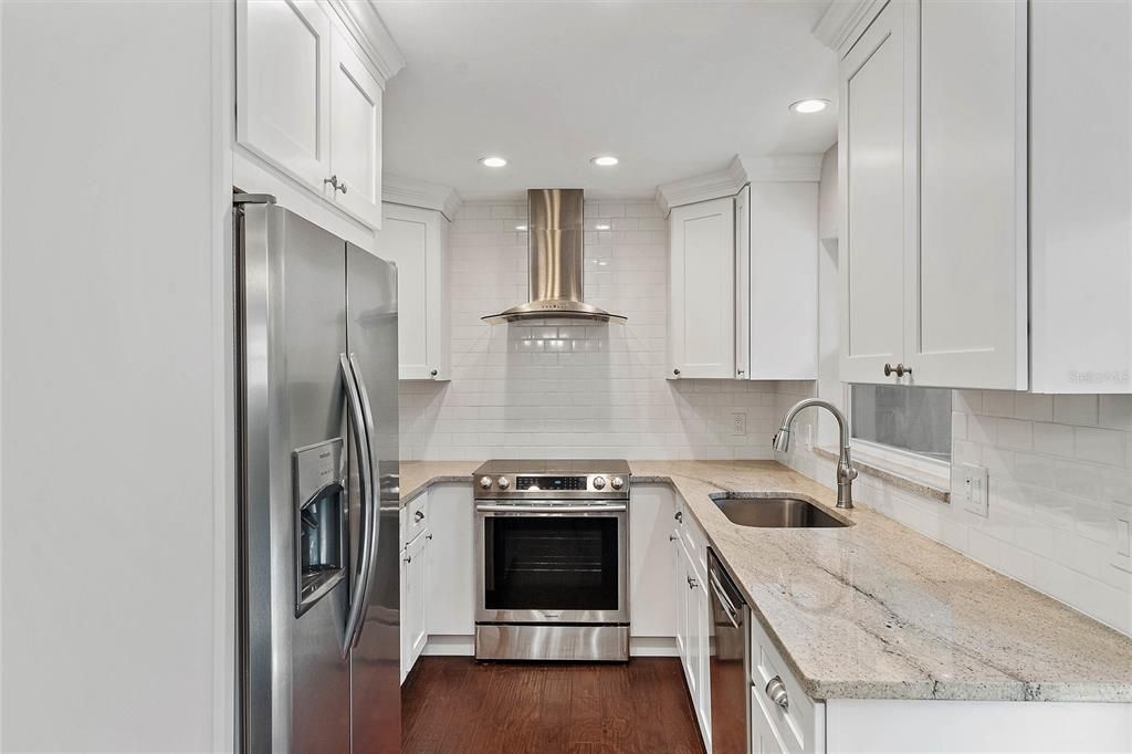 Updated kitchen with granite counters, stainless steel appliances, and shaker cabinets.