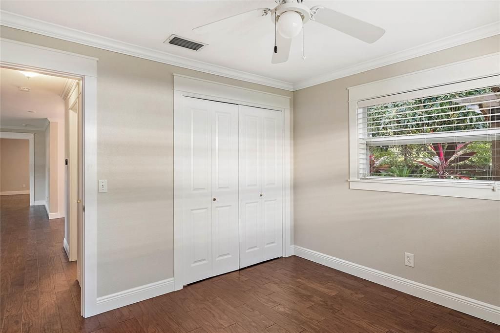 Additional view of the first guest room with the closet doors shut.