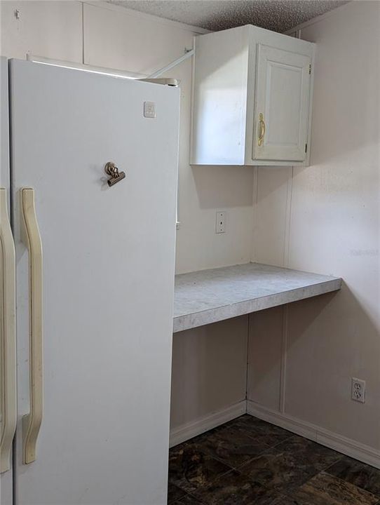 laundry room with extra fridge