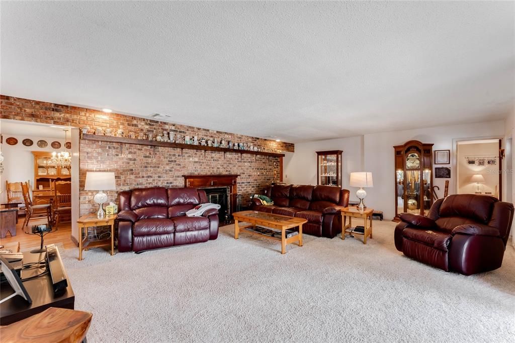 Large Family Room with Brick Wall and Wood Burning Fireplace