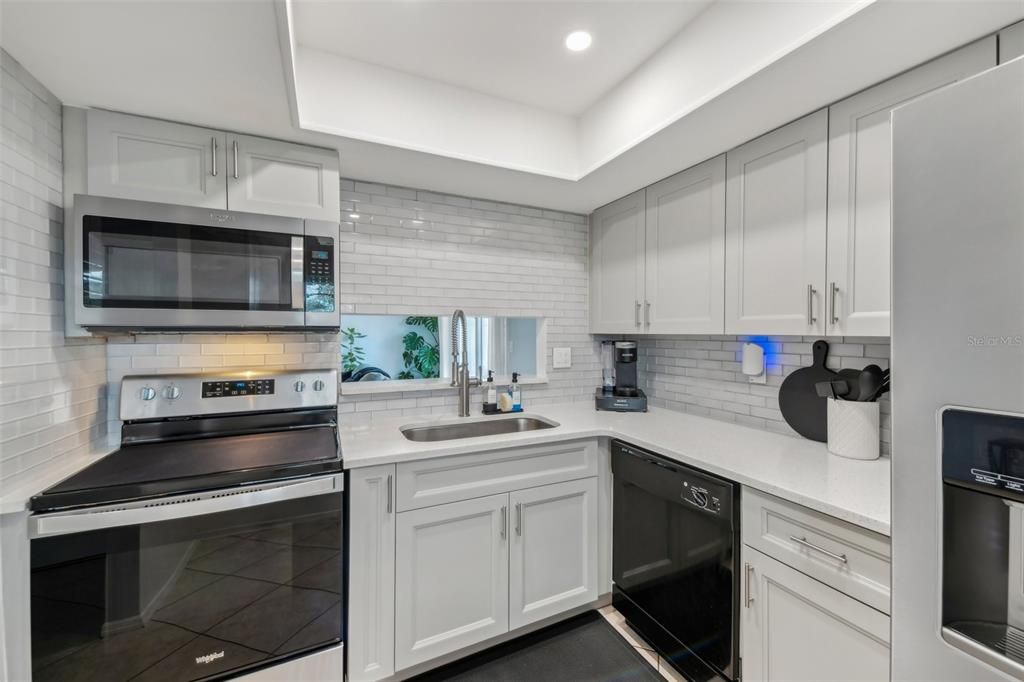 COMPLETE KITCHEN REMODEL with HIGH-END QUARTZ COUNTERTOPS, TILE BACKSPLASH, ALL NEW CABINETS, SUNKEN SINK, UPDATED RANGE, REFRIGERATOR, MICROWAVE AND CUSTOM LIGHTING!