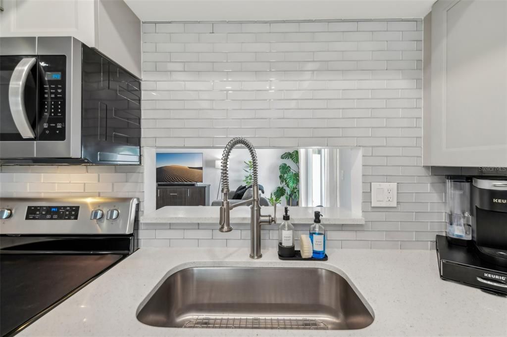 COMPLETE KITCHEN REMODEL with HIGH-END QUARTZ COUNTERTOPS, TILE BACKSPLASH, ALL NEW CABINETS, SUNKEN SINK, UPDATED RANGE, REFRIGERATOR, MICROWAVE AND CUSTOM LIGHTING!