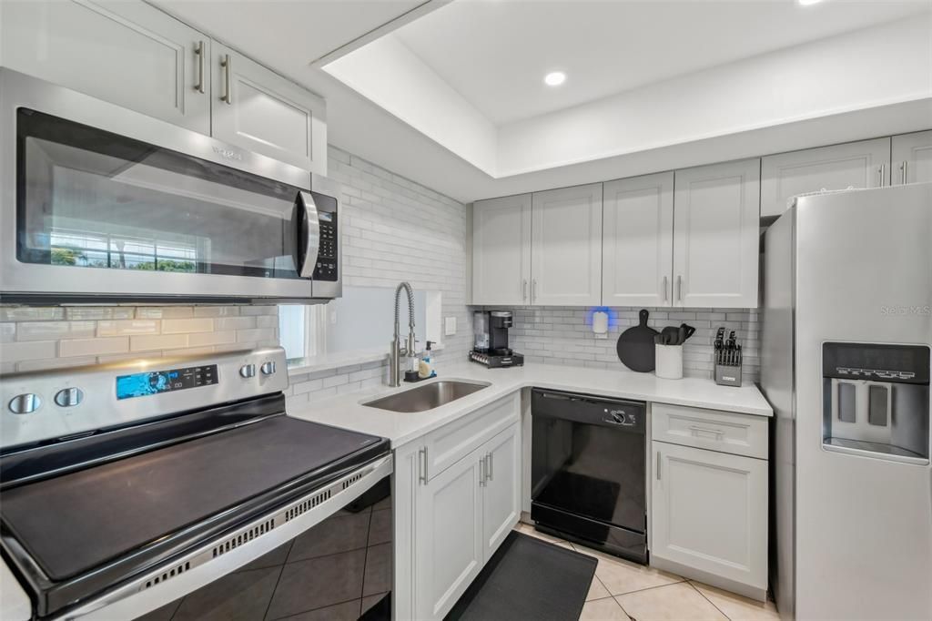 COMPLETE KITCHEN REMODEL with HIGH-END QUARTZ COUNTERTOPS, TILE BACKSPLASH, ALL NEW CABINETS, SUNKEN SINK, UPDATED RANGE, REFRIGERATOR, MICROWAVE AND CUSTOM LIGHTING!