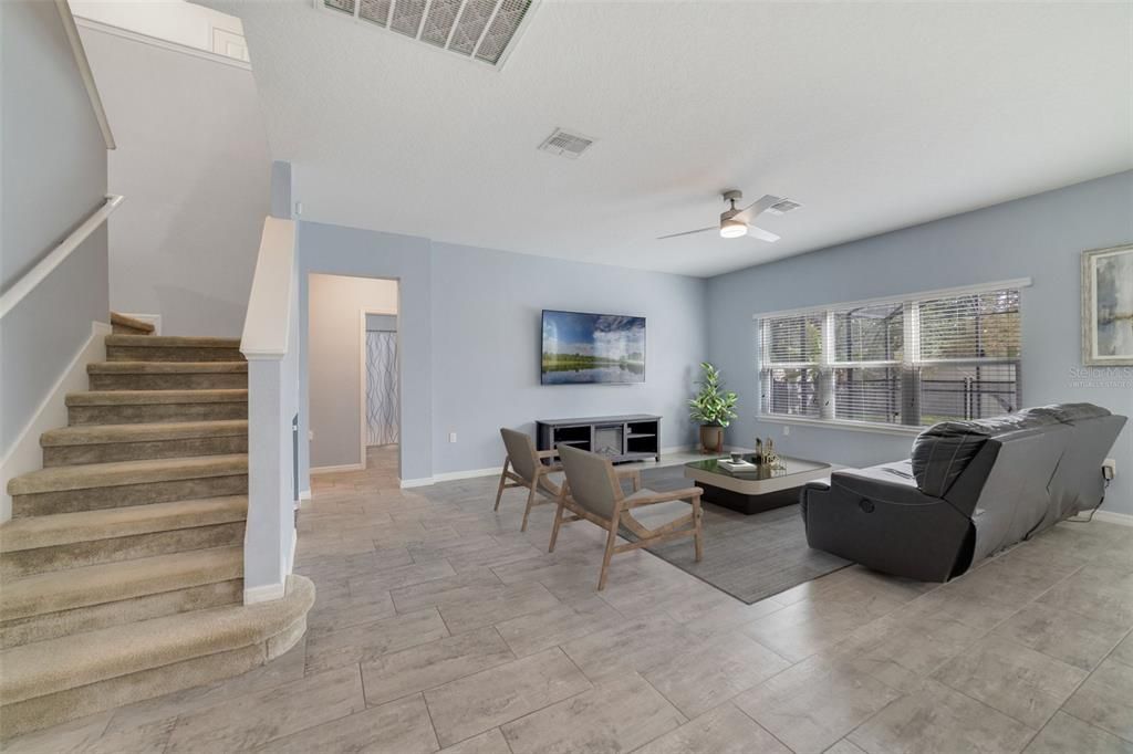 The spacious living area delivers endless natural light with sliding glass door access to the covered lanai and pool. Virtually Staged.