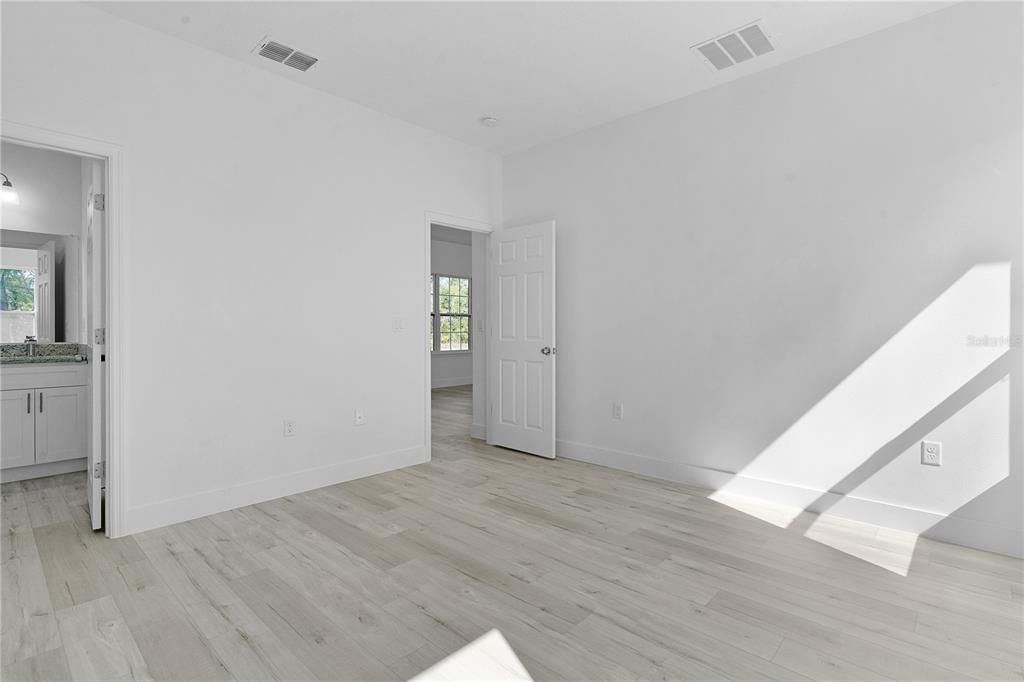 Primary bedroom with ensuite bath door on left and bedroom door on right