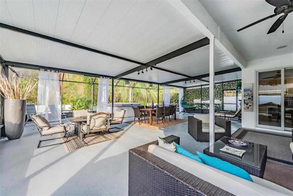 Oversized lanai, partially covered and screened, with lights and ceiling fans.