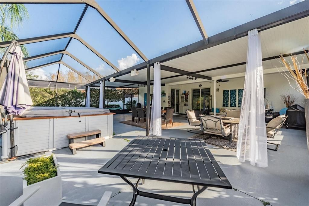 1500 SQ FT Oversized lanai, partially covered and screened, with lights and ceiling fans.