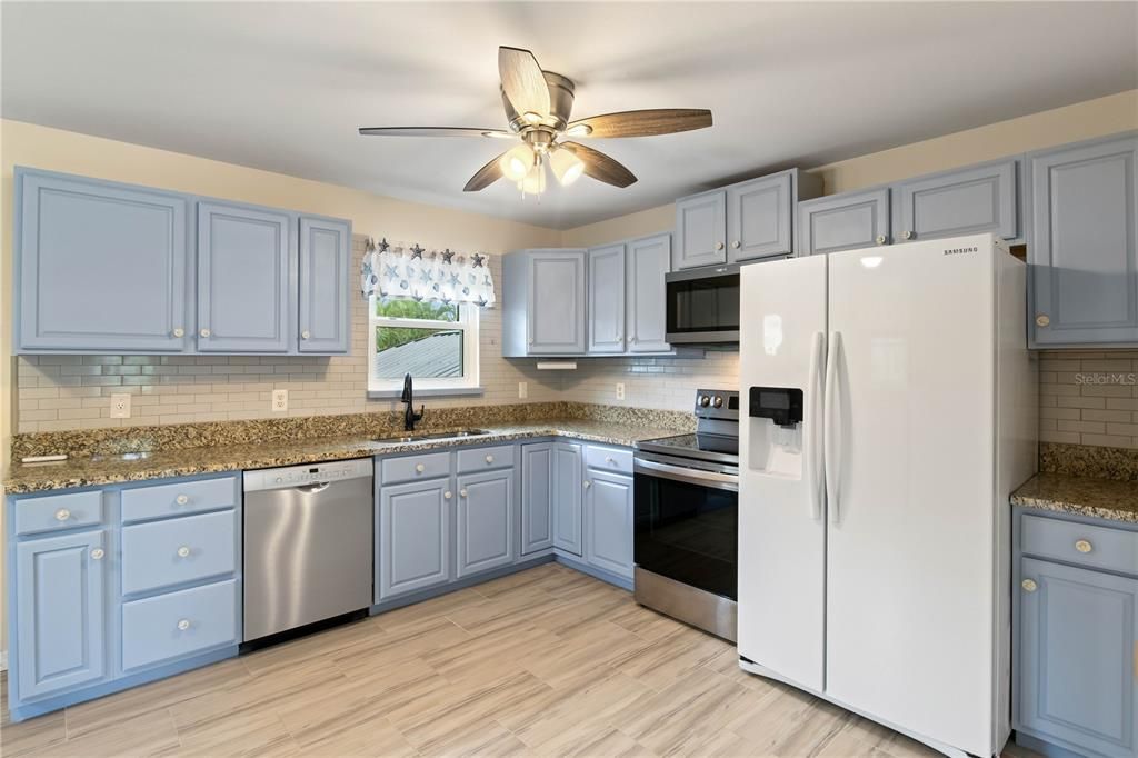 Kitchen featuring a ceiling fan, dishwasher, stove, microwave and fridge