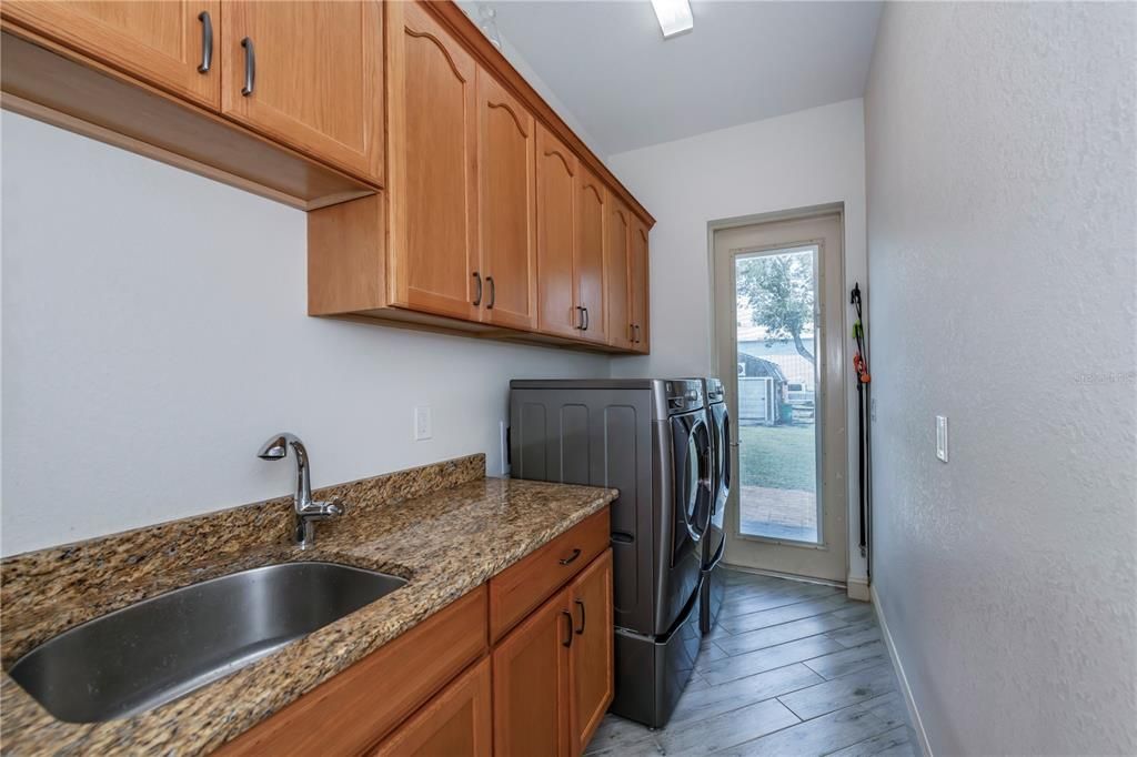 Laundry/utility room opens to the side yard to the sheds and detached building