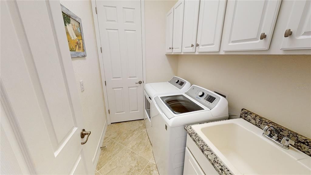 Laundry with tub, cabinets, and handler closet