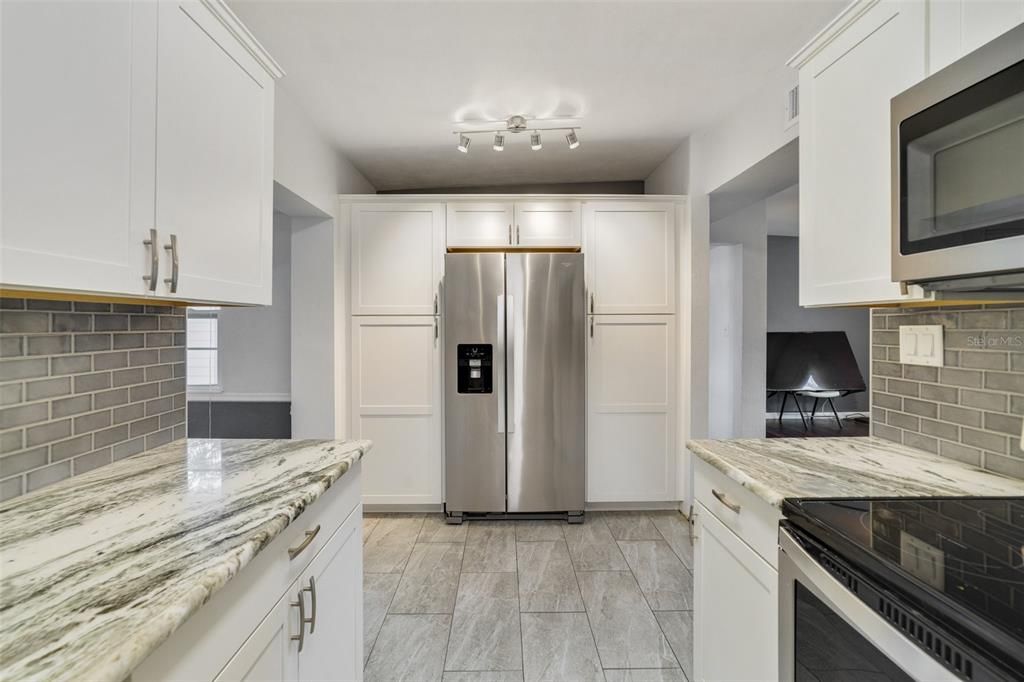 Delivering a modern space for the home chef that includes desirable SHAKER STYLE CABINETRY with soft close, STAINLESS STEEL APPLIANCES, stone countertops, a stylish backsplash and plenty of storage.