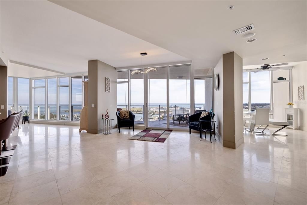 Dining area to the left, sitting area in the middle, entrance to Living Room area on the right. Floor to ceiling windows along that whole eastern side of the condo