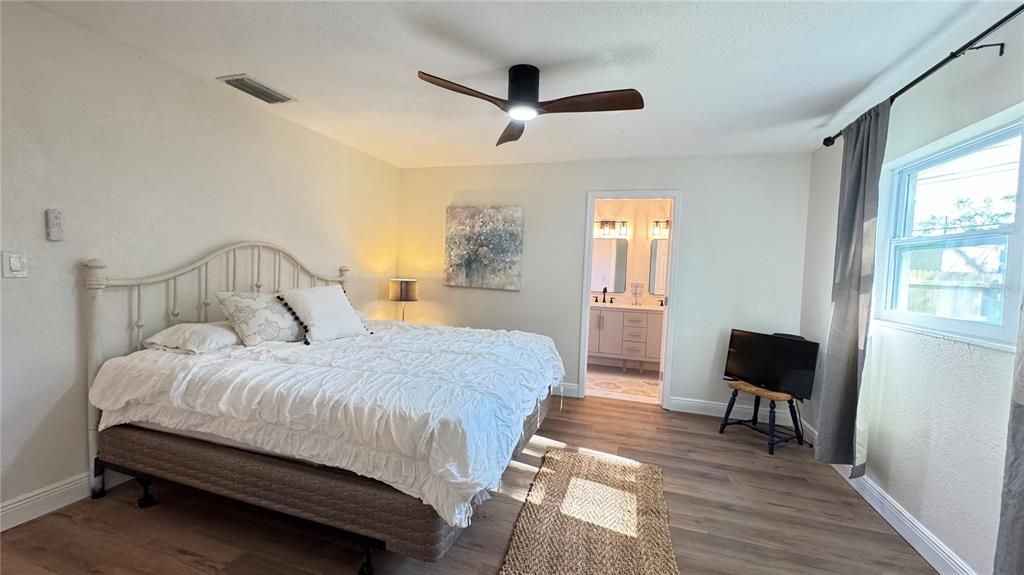 Master bedroom with king bed and window view of backyard