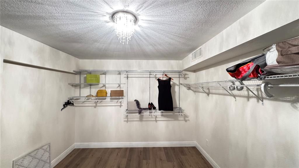 Master suite walk-in closet with beautiful chandelier.