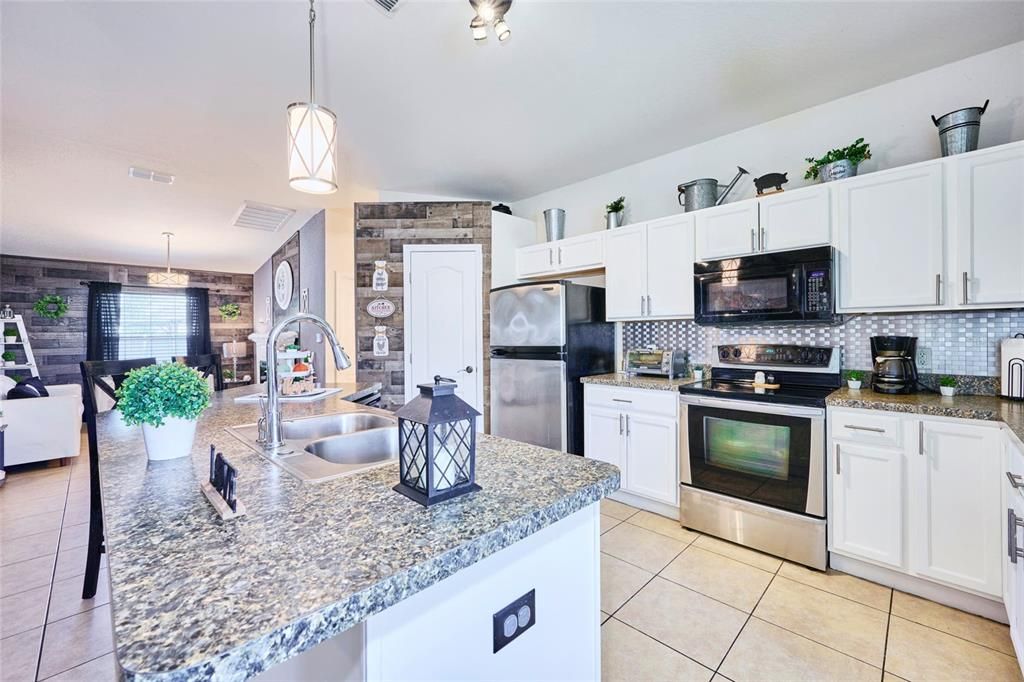 Beautiful kitchen with island and lots of cabinetry space.  The door in the back opens to the spacious pantry.