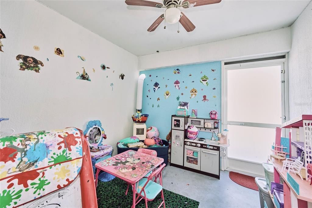 Small patio located off of the family room that was converted to a play room.  The screened door in the back leads out to the back deck.