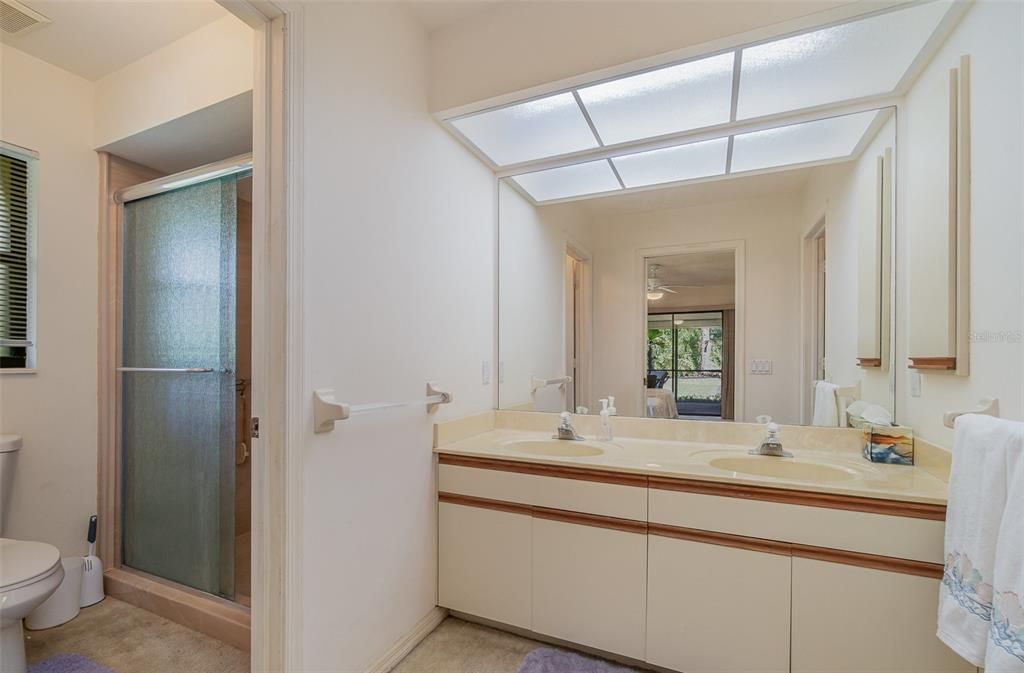 En-suite bathroom featuring dual sinks and a walk-in shower.