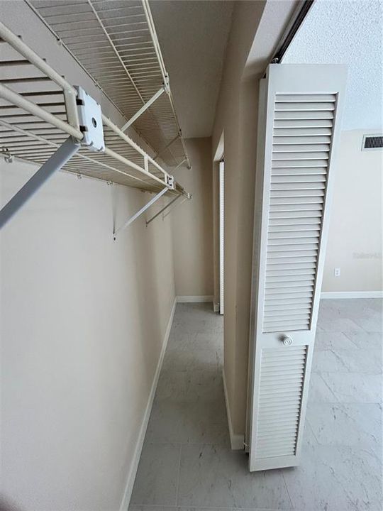 Long double closet in bedroom with shelving