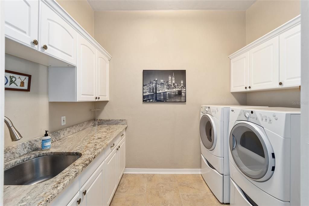 Large Laundry room with sink, extra cabinets and granite countertops