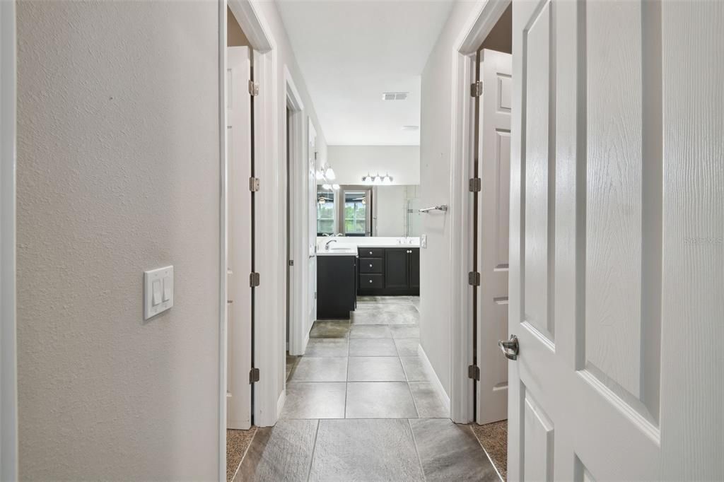 Walk in closets on both sides of entry way to bathroom