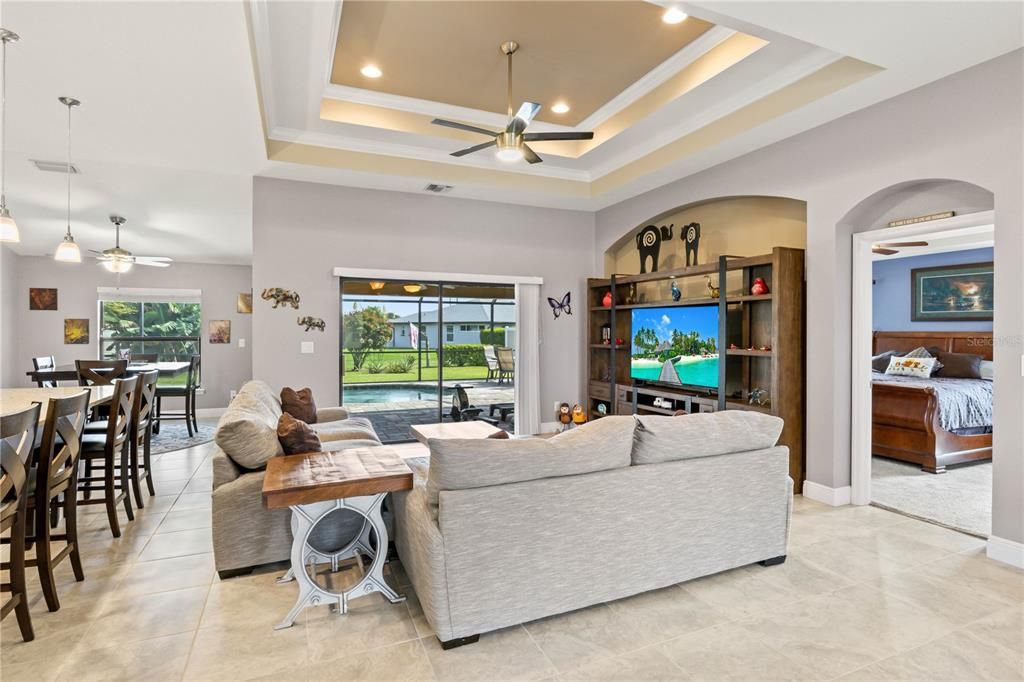 Living room with a healthy amount of sunlight, crown molding, and ceiling fan