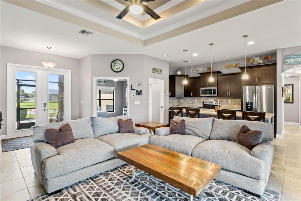 Tiled living room with ornamental molding and ceiling fan