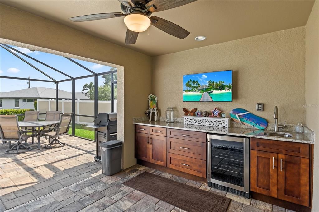 View of patio with ceiling fan, wine cooler, sink, a lanai, and exterior kitchen