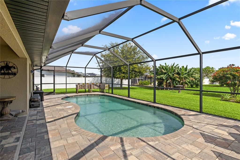 View of pool with a lanai, a lawn, and a patio area