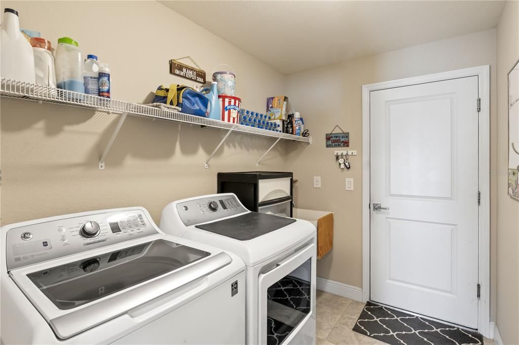 Clothes washing area with light tile patterned floors and separate washer and dryer