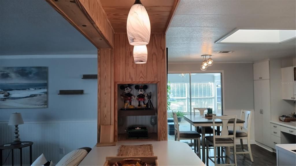 Breakfast bar separates the kitchen from the living room.  Gorgeous pendant lighting over the breakfast bar.  Skylight is shown on the upper right.