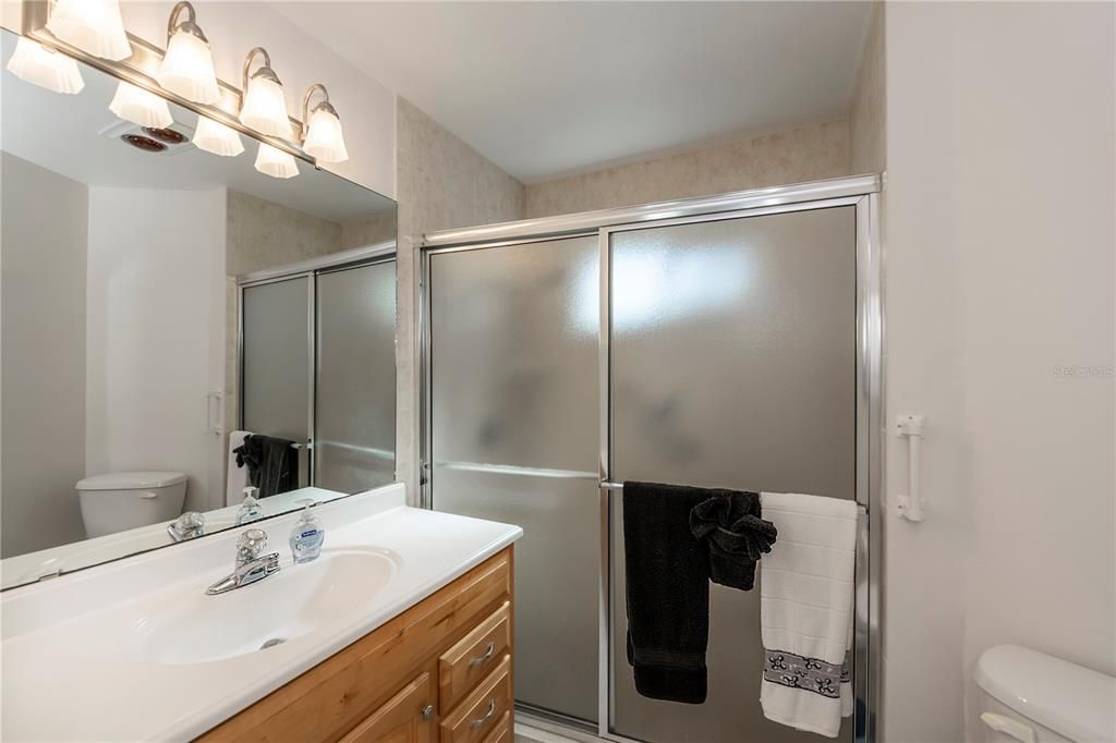 Primary bathroom with walk-in shower and vanity.