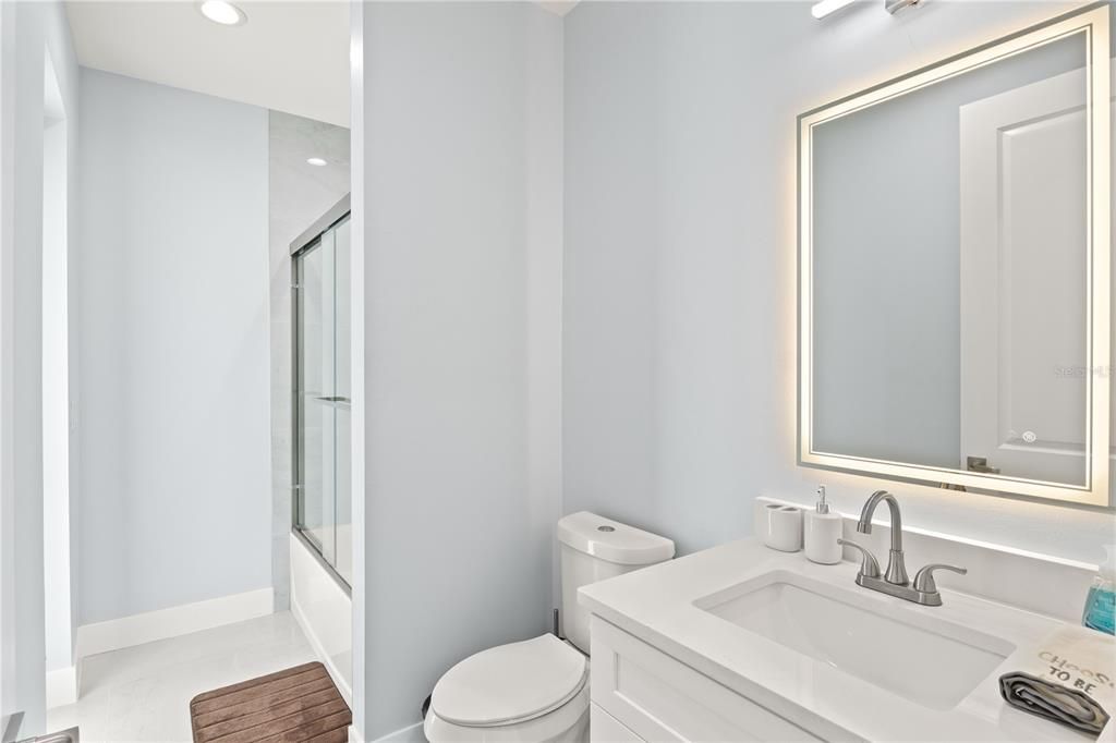 Full bathroom with tile patterned floors, shower / bath combination with glass door, vanity, and toilet