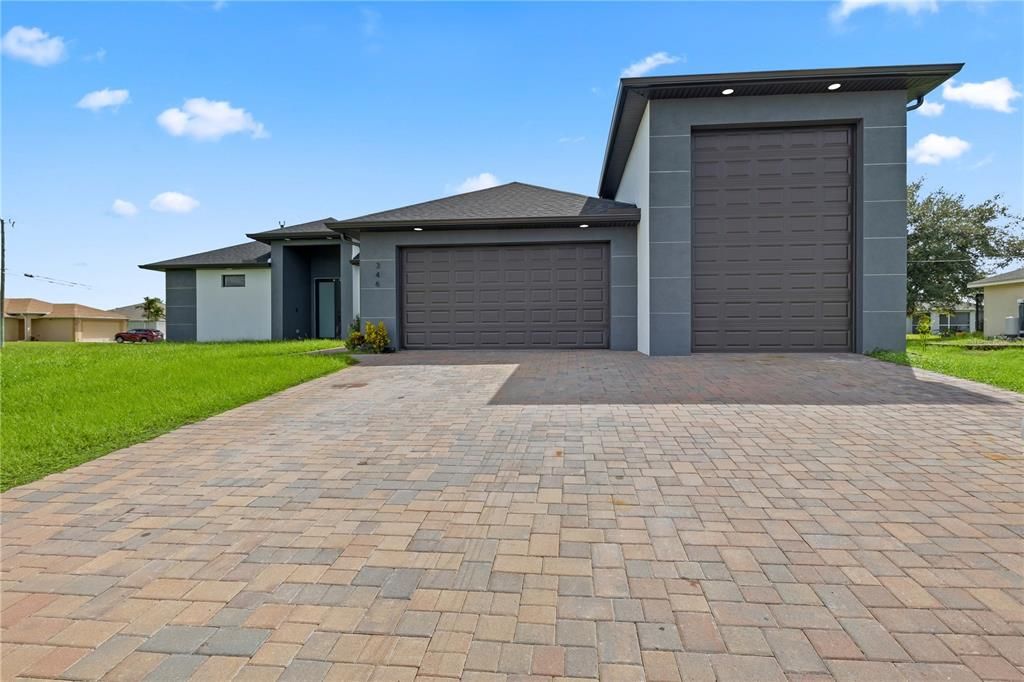 View of front facade featuring a garage and a front lawn