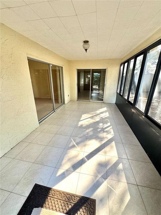 Nice tiled lanai with glass windows.