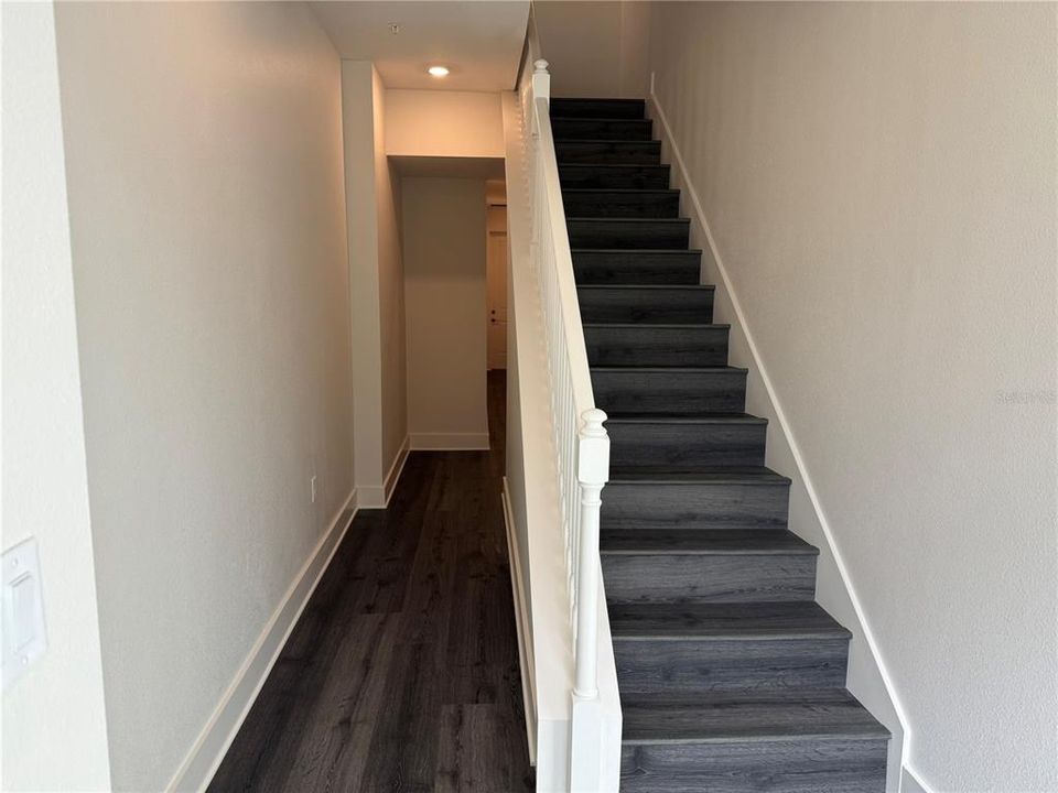 FOYER STAIRCASE UP AND HALLWAY TO OUTDOOR SPACE & GARAGE