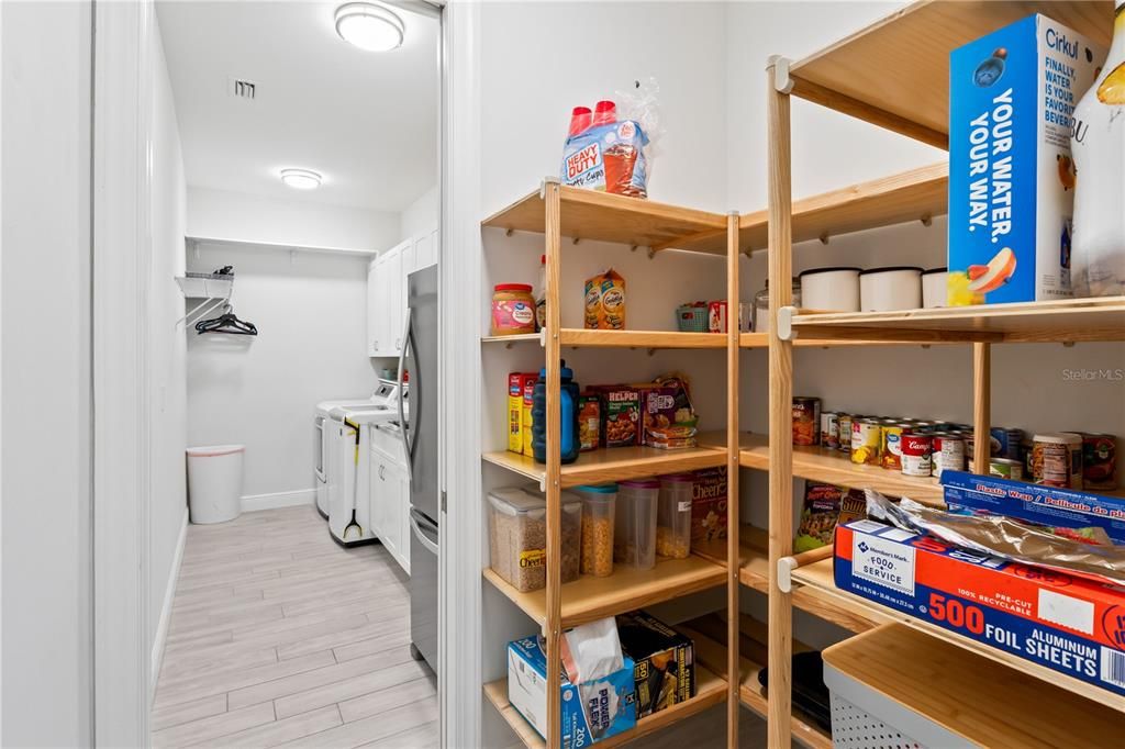 An oversized pantry with spacious shelving and plenty of room for storage - there is also additional cabinetry which is perfect for a coffee/wine station. The laundry room is super spacious also with an abundance of cabinets!