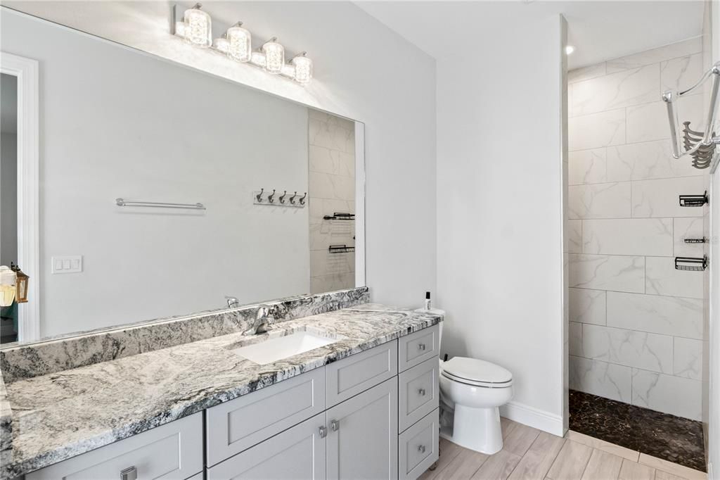 A luxurious guest bathroom with walk-in shower, upgraded high level granite and more of those custom touches you will find throughout this amazing home!