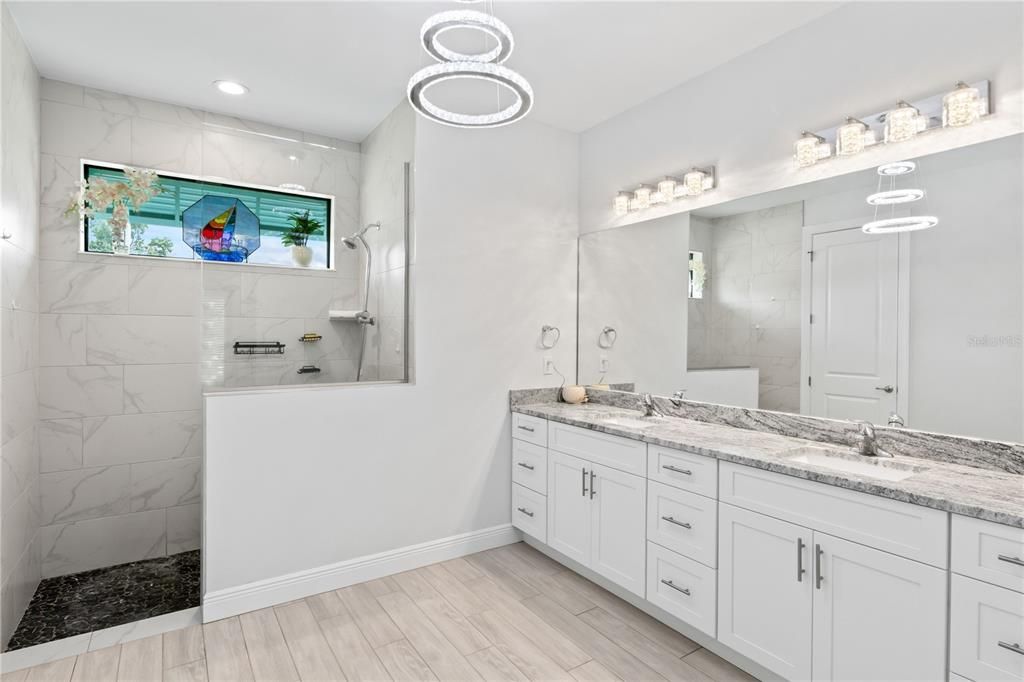 No short cuts here again custom tile, two vanities granite countertops. The transom window allows natural light. Two master closets and a private commode.