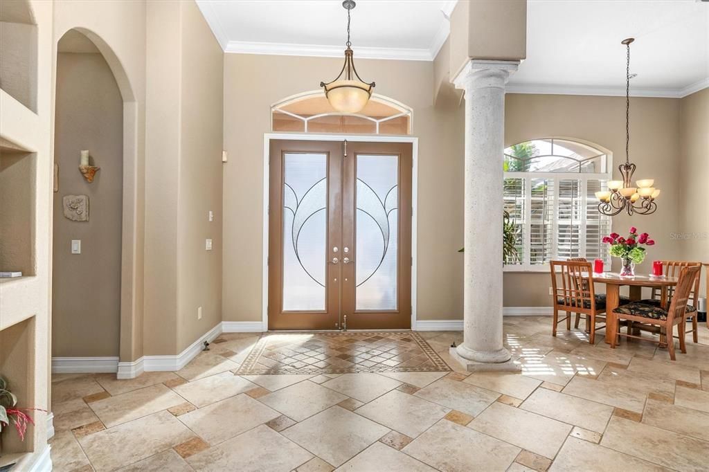 Custom double doors with lead glass insets, retractable double screen door, specialized designed flooring in entry pad. Sweeping cathedral ceilings with double tray and lighting.