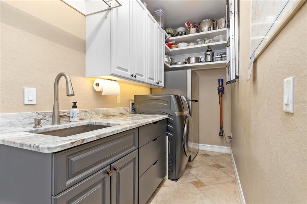 Brand new Laundry room in house with granite countertop, stainless steel sink, plenty of built-in cabinets, "all in one" washer/dryer, stainless steel refrigerator.