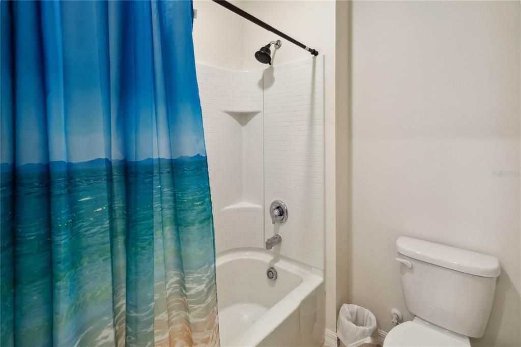 Third bathroom view of shower and tub.