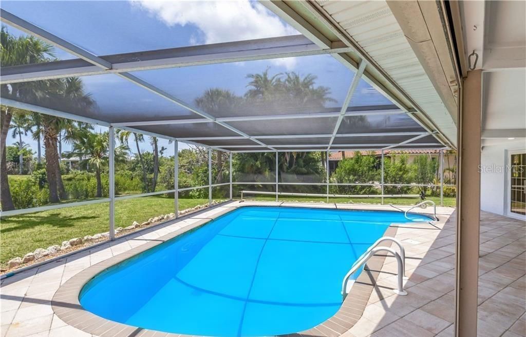 View of swimming pool featuring a patio area, a lanai, and a yard