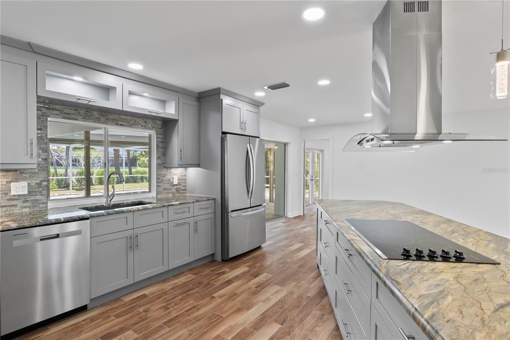 Sleek, gourmet kitchen with stainless steel appliances, highly upgraded countertops, and a spacious island, ideal for culinary adventures and family gatherings.