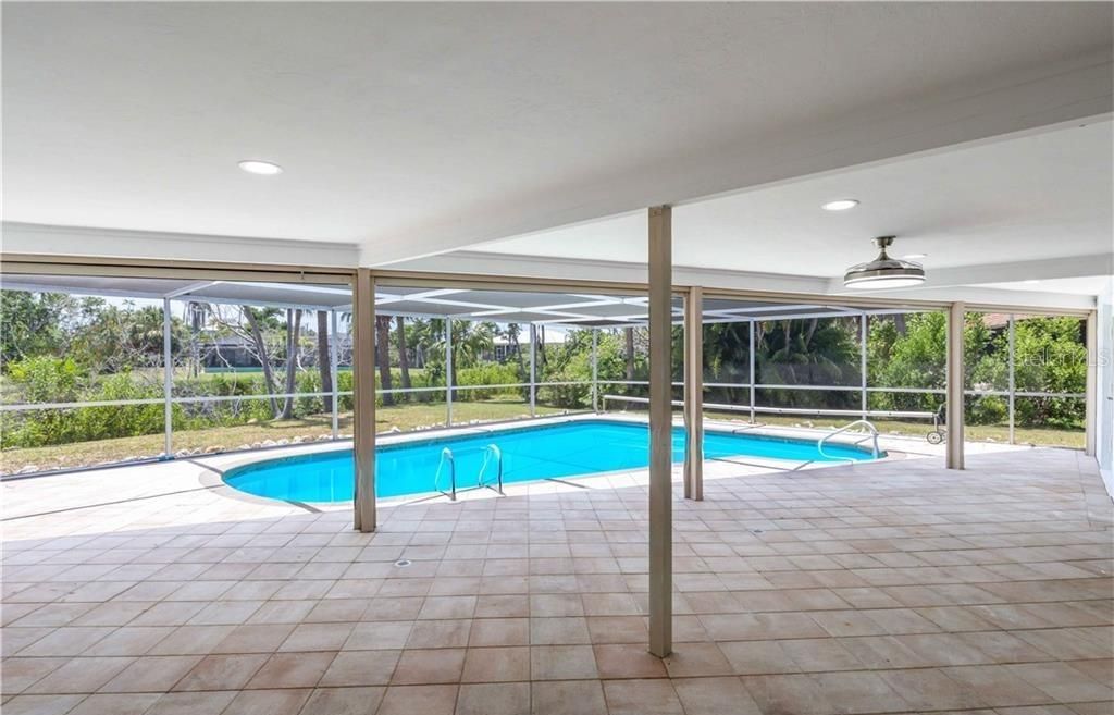 View of swimming pool with a patio, a lanai, and ceiling fan