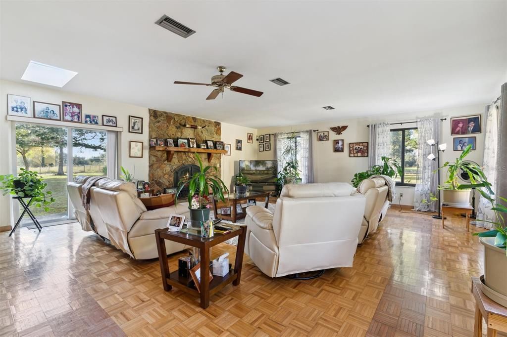 Family room with parquet flooring and fireplace. So much light coming in!