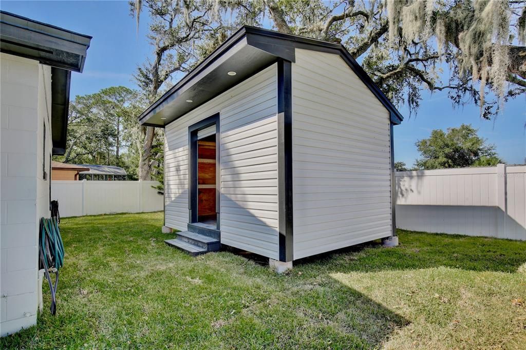 Outdoor workshop and storage shed w/full electrical hookups. Aproximately 9.6 x 15.3.