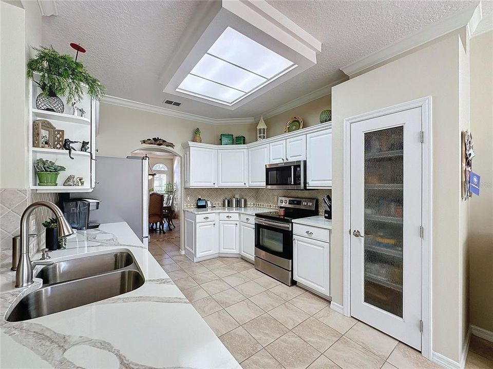 Kitchen has Quartz counters w/tile backsplash